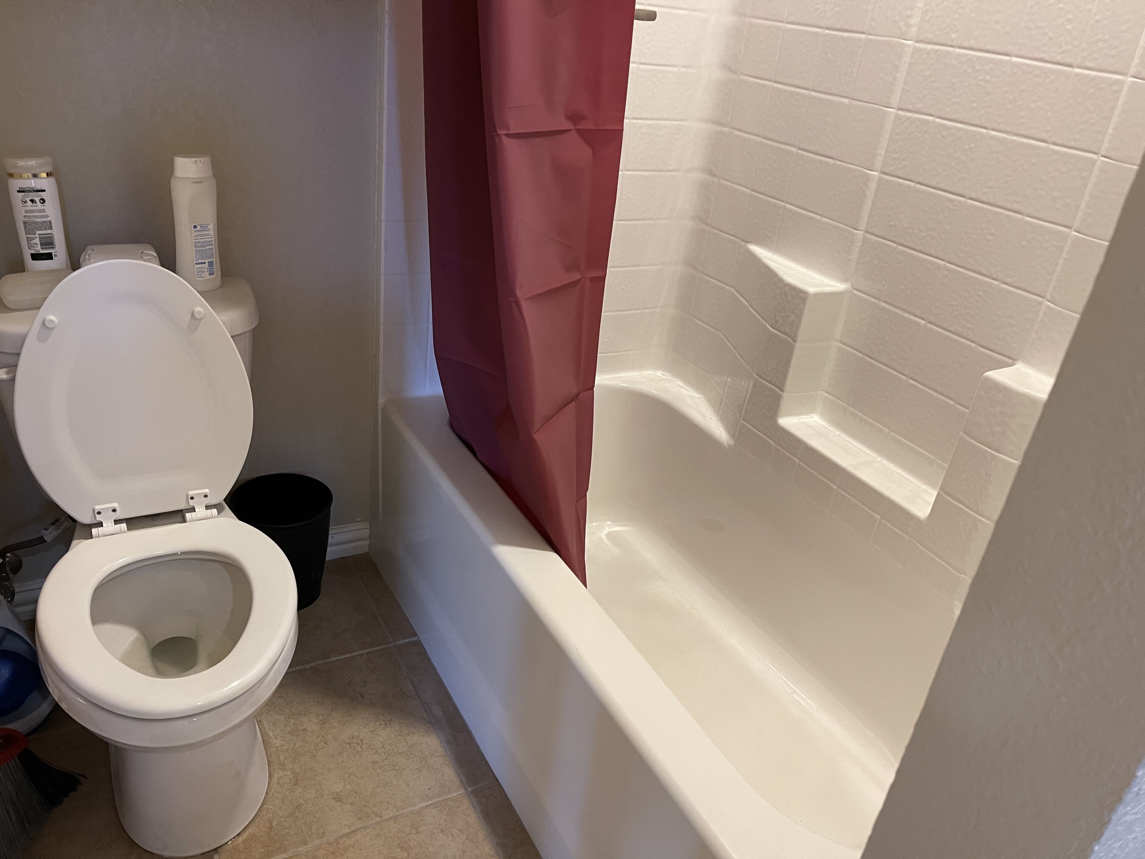 Ein Badezimmer mit Toilette, Duschvorhang und Badewanne.