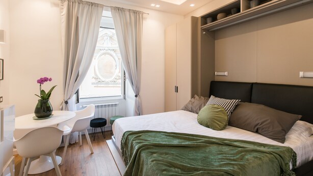 A modern bedroom with a bed, a desk, and a chair. - Charming Trastevere home overlooking a medieval church: suite, 3 baths, WiFi, AC (Roma)
