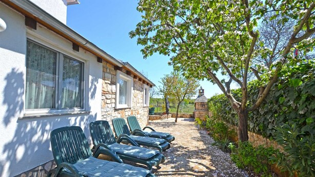 A stone building with a row of green lounge chairs outside. - Bavica Apartment with private parking (Rovinj)