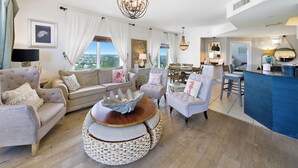 Un salon spacieux avec une grande fenêtre, un coin repas et une cuisine.