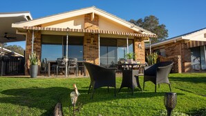 A house with a covered patio, outdoor seating, and a brick facade. - 29A Ballina Crescent, Port Macquarie (Port Macquarie)