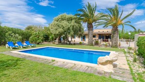 A swimming pool with blue water, surrounded by a grassy area and blue lounge chairs. - Villa with private pool near Manacor,  Villa con piscina privada en Manacor, YourHouse Garballons (Manacor)