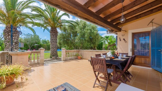 An outdoor patio with a wooden pergola, a table with chairs, and potted plants. - Villa with private pool near Manacor,  Villa con piscina privada en Manacor, YourHouse Garballons (Manacor)