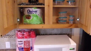 A kitchen with a microwave, a bag of Chiquita bananas, and plastic containers on shelves. - $89/night for 2 people, plus $20/night for each additional person (Pahrump)