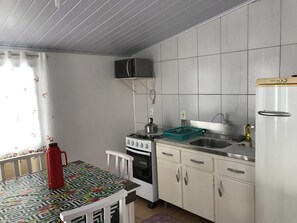 A compact kitchen with a stove, microwave, sink, and cabinets.