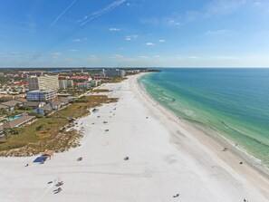 A wide beach with clear water, a few people, and buildings along the shore. - Siesta Key Beach Resort Jamaica Royale (Siesta Key)