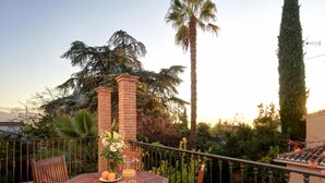 Un tavolo e sedie in legno su un balcone, con una piscina sullo sfondo.