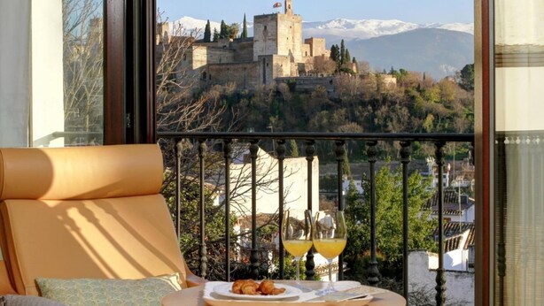 Un balcone con vista su un castello e montagne.