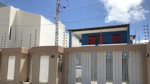 Un lotissement résidentiel fermé, doté d’une porte blanche, d’un immeuble bleu avec des portes rouges et d’un immeuble beige portant le numéro « 75 ».