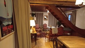 Une pièce chaleureuse avec un plancher en bois, une table à manger et un escalier.