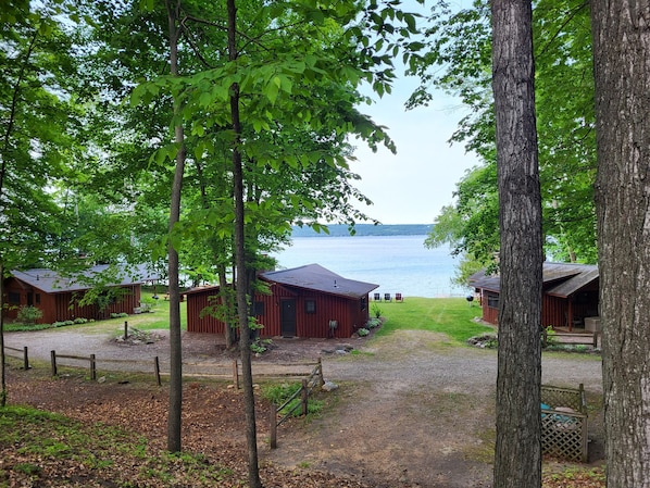 Zona de cabañas junto al lago, con varias cabañas de madera, un camino de grava y vistas al lago.
