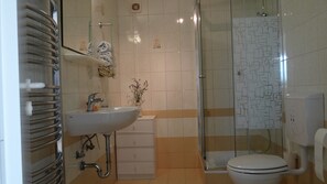 A bathroom with a glass shower enclosure, a white sink with a faucet, and a toilet. - Bonini Apartments - Adults Only (Koper)