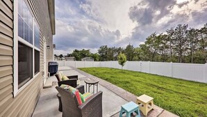 A patio with outdoor furniture, a small table, and a grassy yard enclosed by a white fence. - Percy priest Lake House (La Vergne)