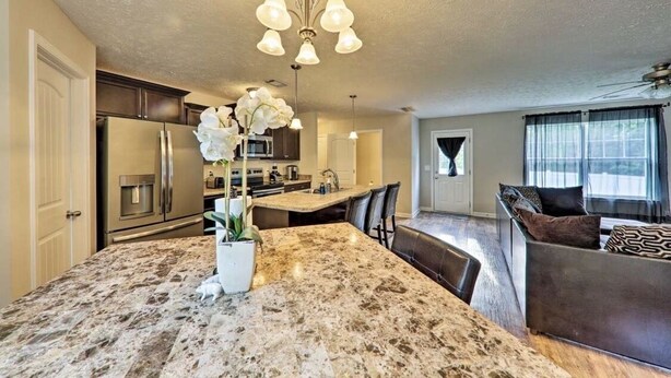 A modern kitchen with granite countertops, stainless steel appliances, and a central island. - Percy priest Lake House (La Vergne)