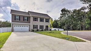 A two-story house with a garage, a driveway, and a well-maintained lawn. - Percy priest Lake House (La Vergne)