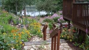 A garden with a stone pathway leading to a wooden deck.