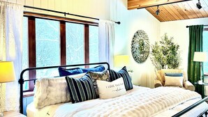 A bedroom with a bed, bedside tables, a mirror, and a window with curtains. - Lovely 3br/2ba Hideaway! Great for Groups & Families! Inlet & Denali Views (Anchorage)