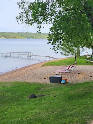 Relax on the lakeside beach with comfortable chairs and a shaded area, perfect for sunbathing and water activities.