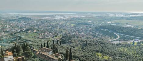 Une vue panoramique d’une ville où se côtoient des bâtiments résidentiels et commerciaux, le tout entouré de verdure et bordé par une rivière.