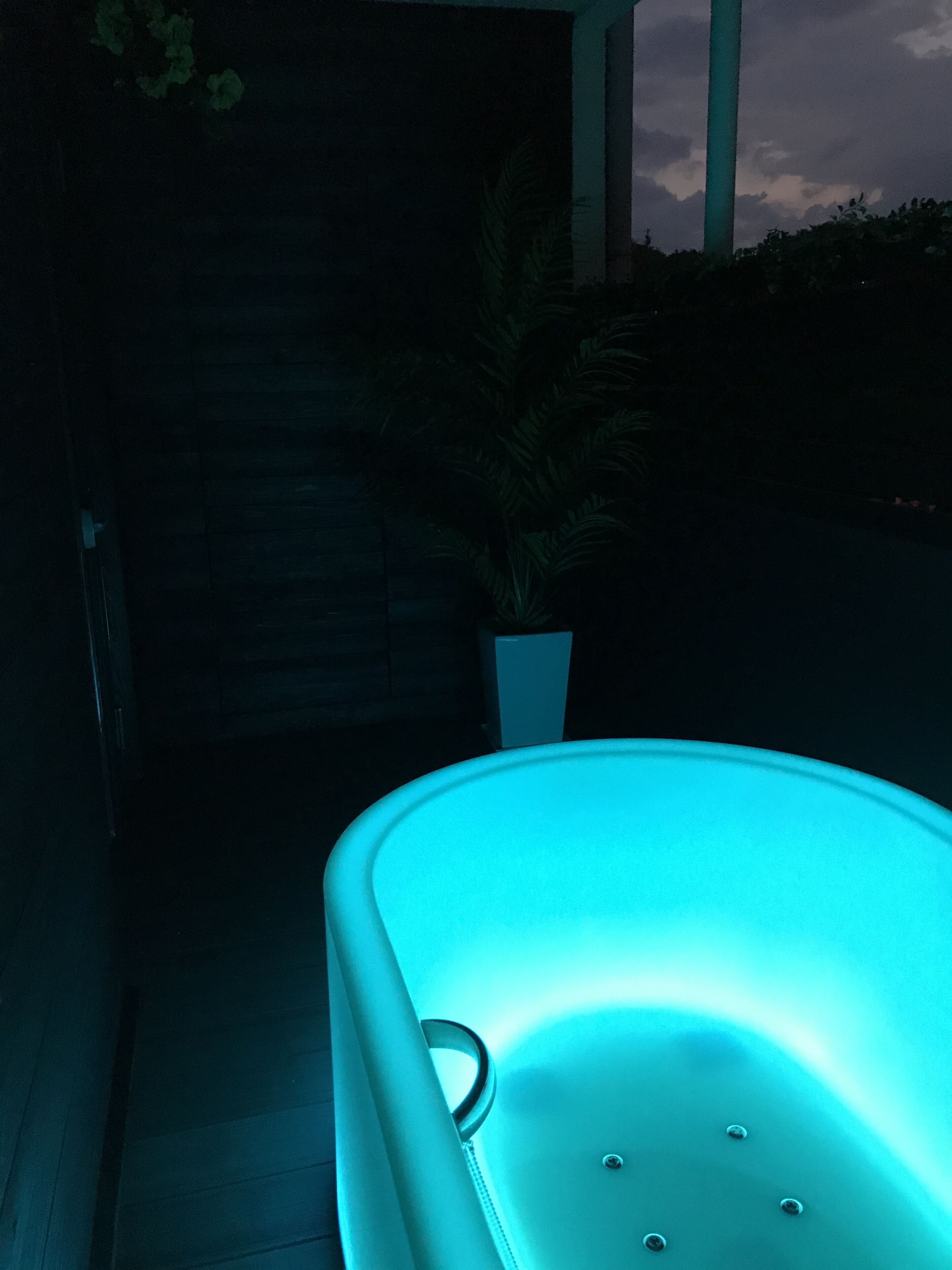 A modern outdoor seating area with a teal-colored chair and a potted plant.