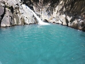 A natural pool with clear turquoise water, surrounded by rocky cliffs. - Wooden chalet, sea view (SAINT -CLAUDE)