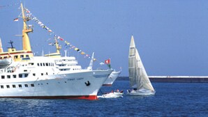 A large cruise ship named 'First Lady' with multiple decks and flags, sailing in the ocean.