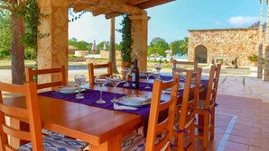 An outdoor dining area with a stone wall and wooden furniture. - Casa Fina, Holiday house in Felanitx, Mallorca (Felanitx)