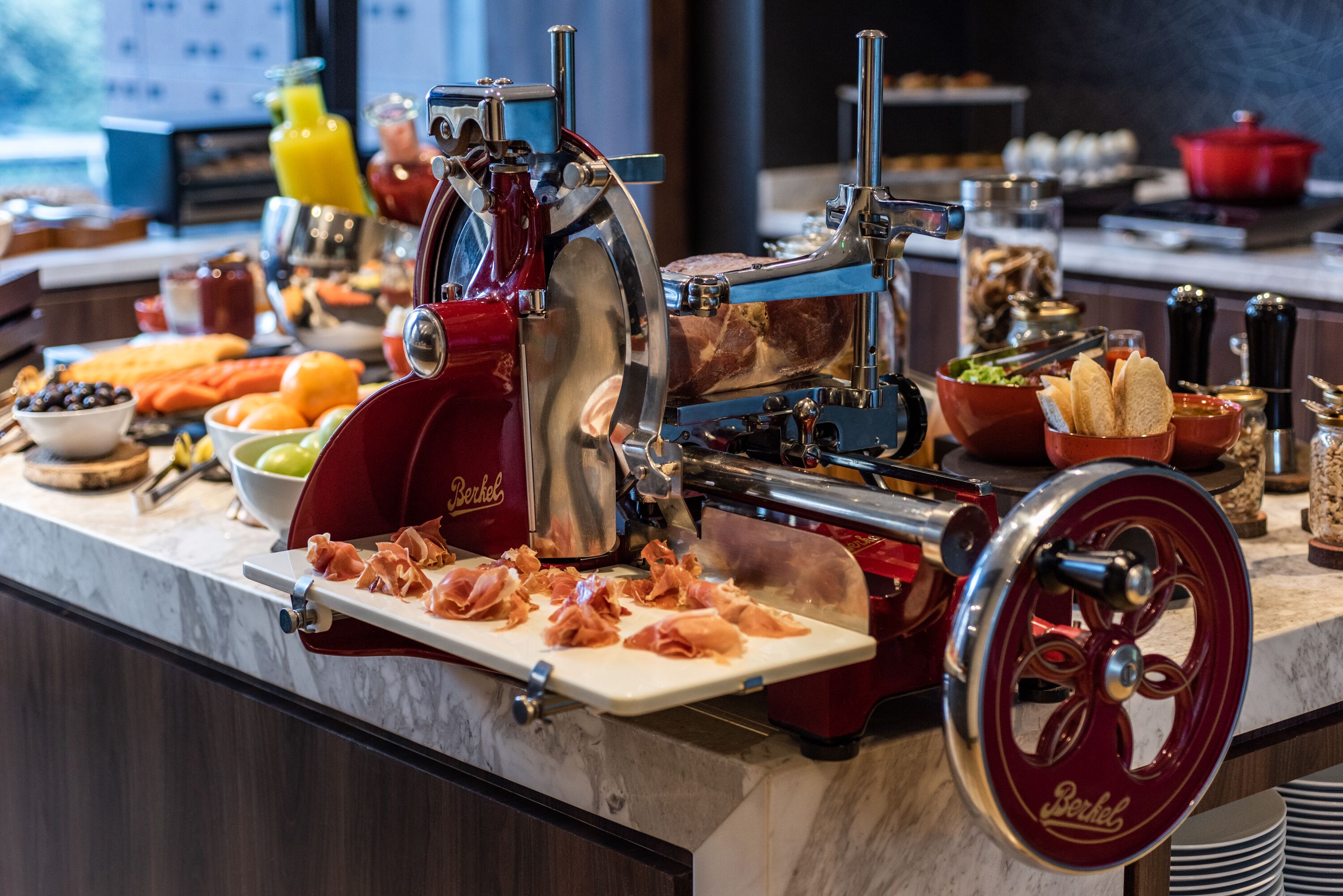 Ein reichhaltiges Buffet mit Aufschnittmaschine, verschiedenen Speisen und Beilagen.