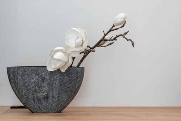 A large, dark gray bowl with a single orchid branch. - Yasuragi Niseko (Kutchan)