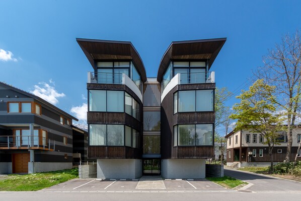 A modern building with a symmetrical design, featuring large windows and a central entrance. - Yasuragi Niseko (Kutchan)