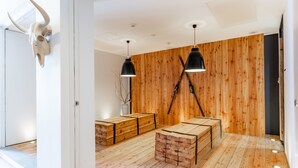 A modern room with wooden walls, a large wooden table, and two black pendant lights.