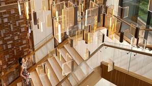 A modern interior with a glass staircase, wooden paneling, and contemporary lighting fixtures. - The Ritz-Carlton, Xi'an (Xi'an)