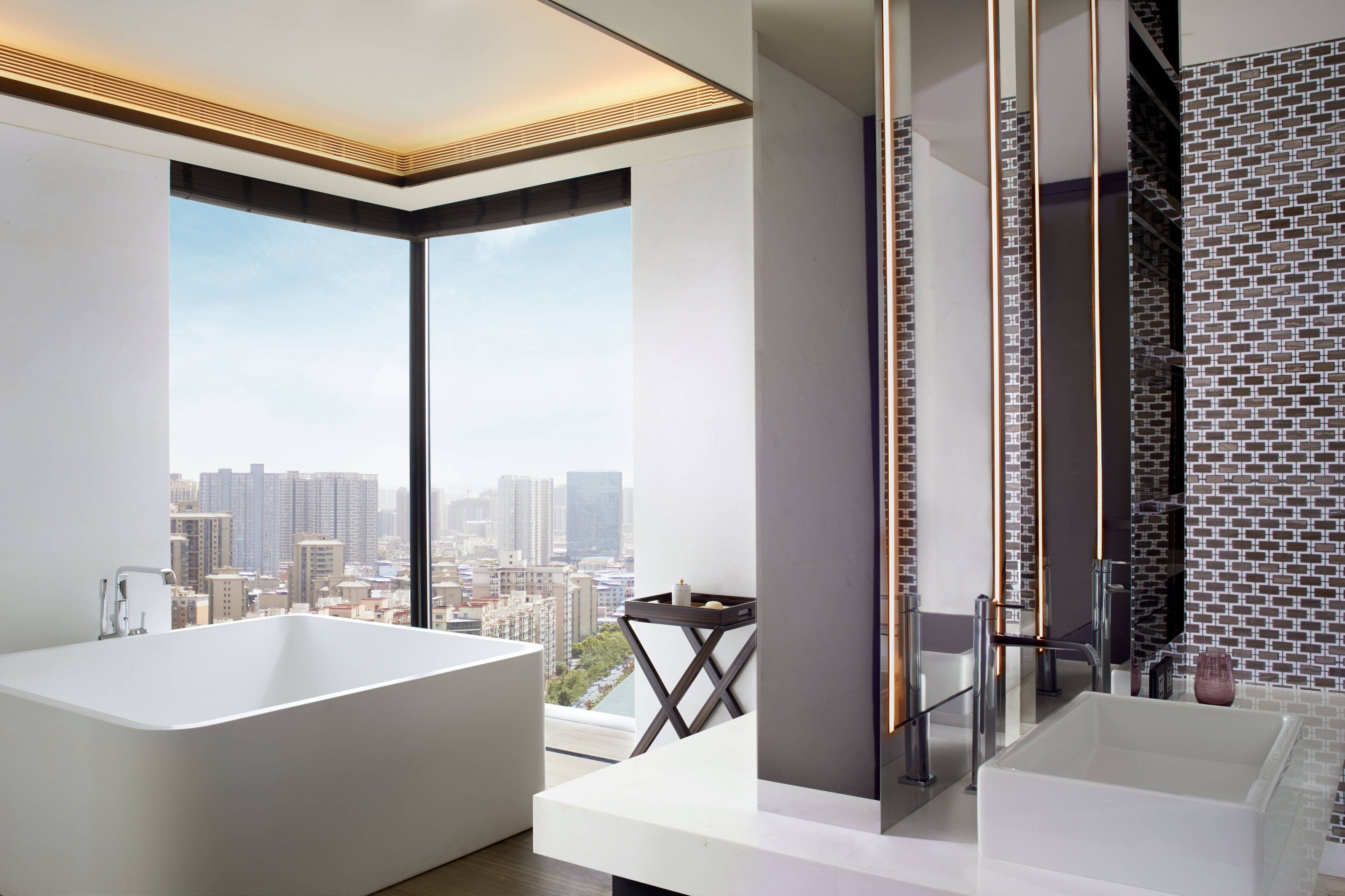A modern bathroom with a large bathtub, a smaller sink, and a glass shower enclosure.