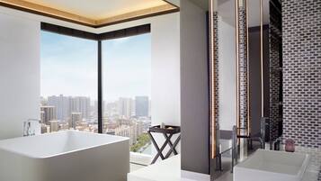 A modern bathroom with a large bathtub, a smaller sink, and a glass shower enclosure.