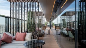 A modern rooftop lounge with a glass balustrade, seating areas, and a view of the cityscape. - The Ritz-Carlton, Xi'an (Xi'an)