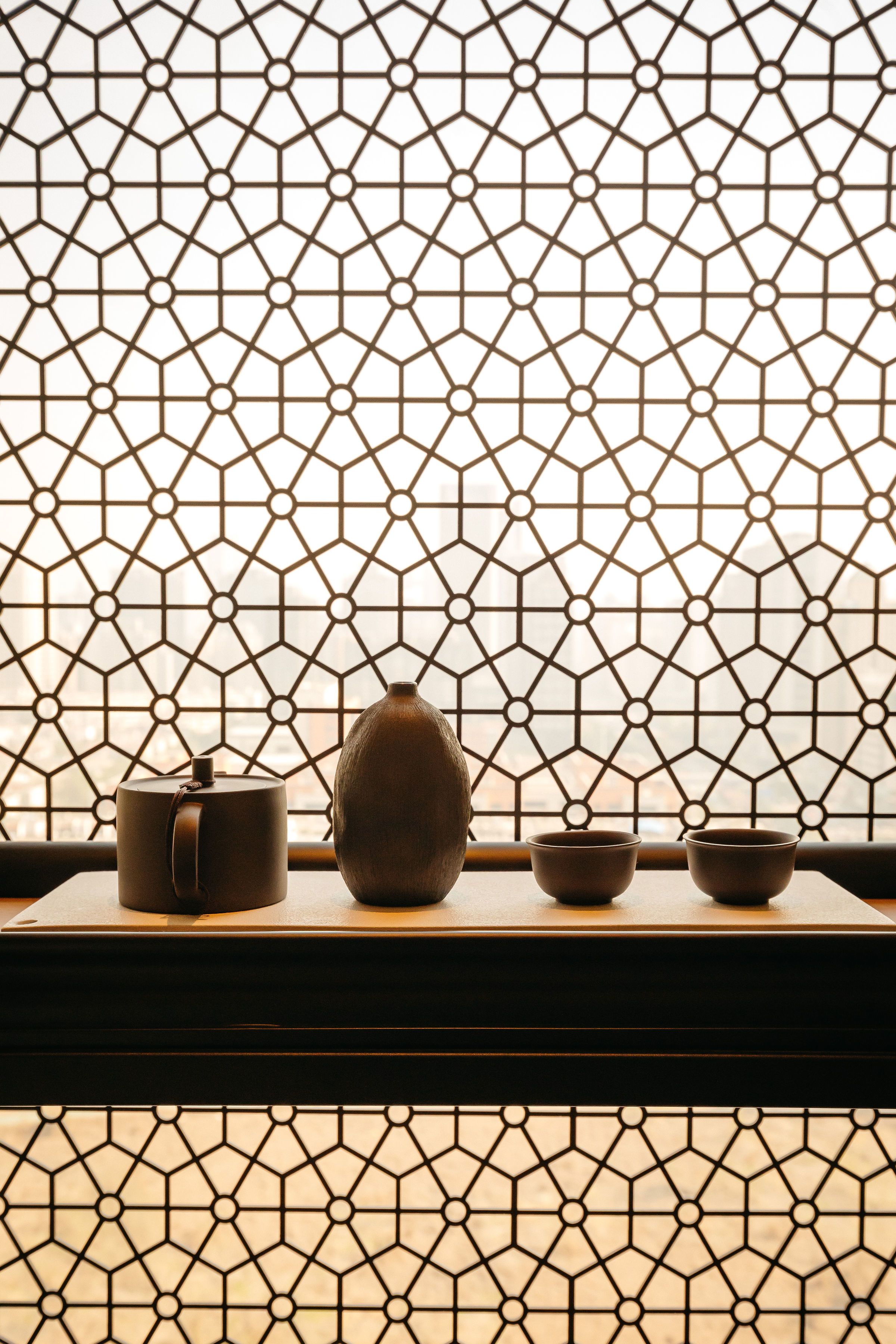 Une pièce de style japonais traditionnel, avec un sol recouvert de tatamis, un paravent en papier de riz (shoji) et un ensemble à thé posé sur une petite table basse.