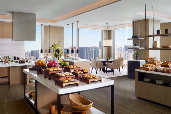 A modern kitchen with a city view, featuring a breakfast buffet with various pastries and fruits. - The Ritz-Carlton, Xi'an (Xi'an)