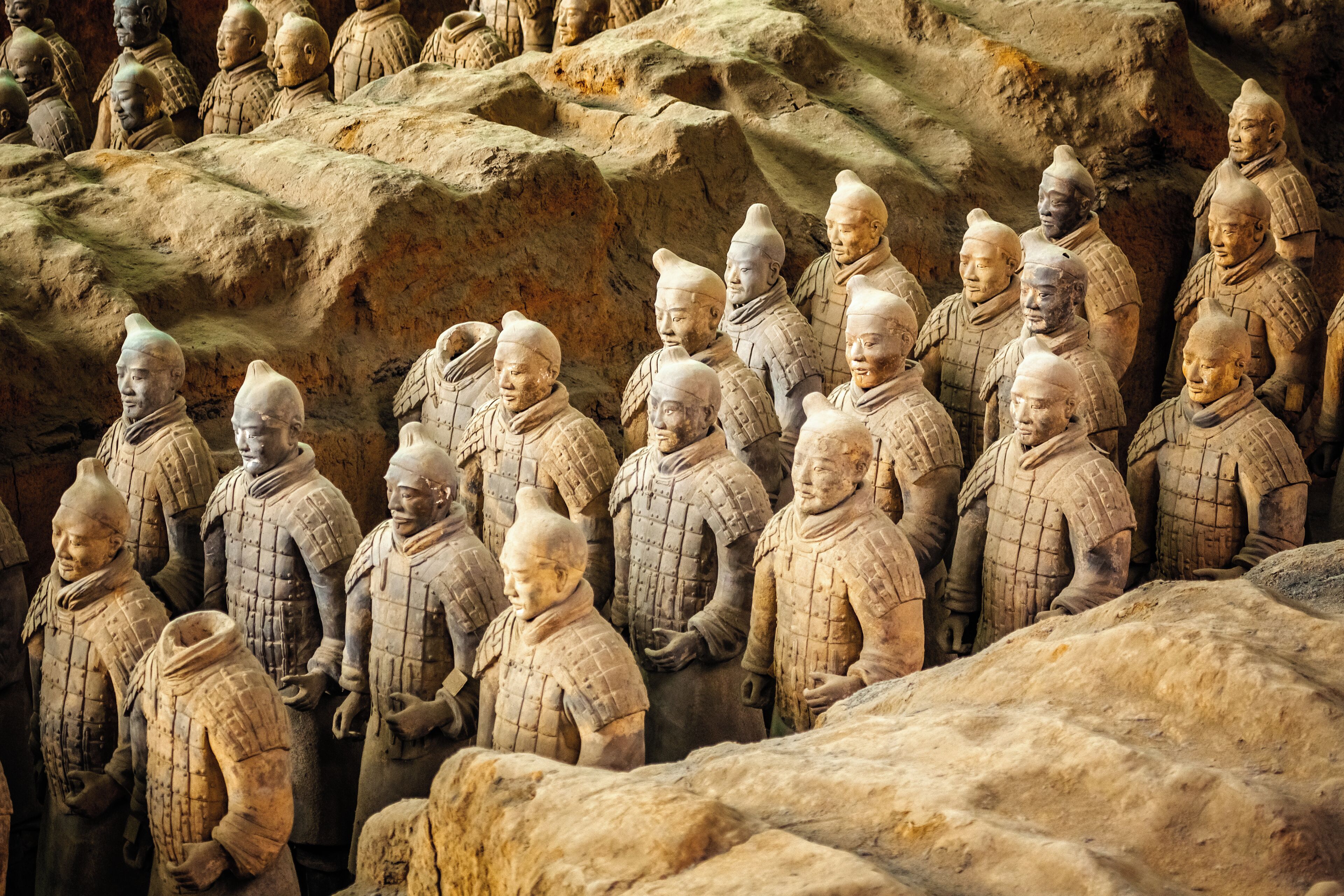 Una fila de soldados de terracota en una tumba de piedra.