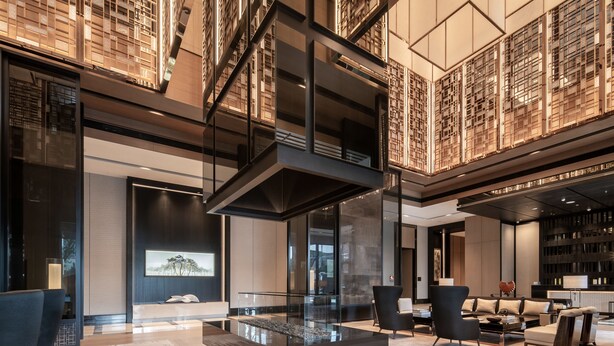A modern interior with a central glass table, seating area, and a bookshelf. - The Ritz-Carlton, Xi'an (Xi'an)