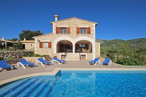 A stone villa with a pool, outdoor seating, and a view of the hills. - Ses Rotes - Spacious country house with private pool for 10 people in Mallorca (Campanet)