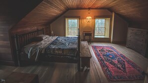 A cozy attic bedroom with a wooden ceiling, a large bed, a nightstand, a dresser, and a window with a view. - Funks Inn, a post civil war era home restored as it was in 1870. (Bloomsdale)