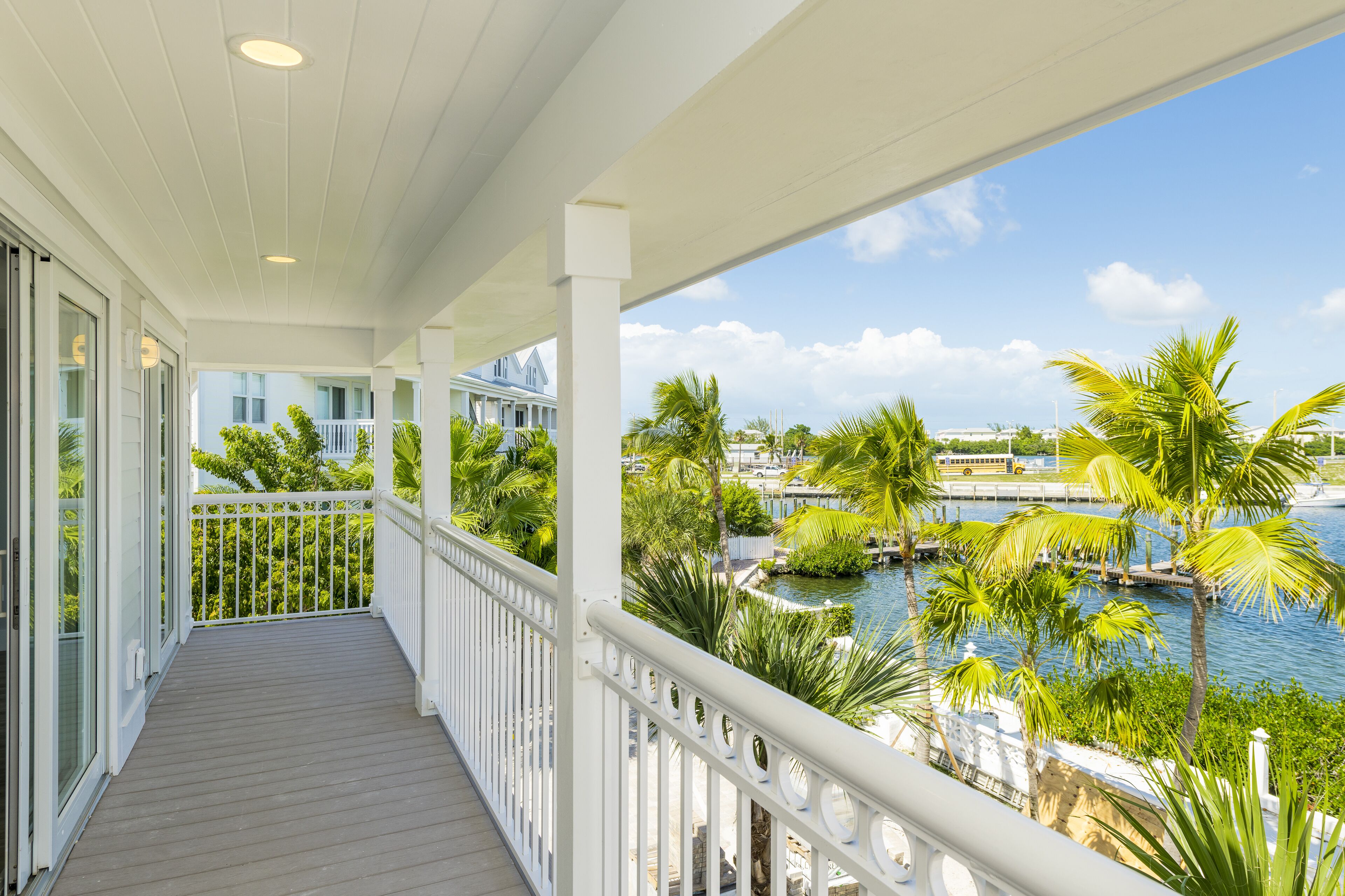 A balcony with a view of a marina and palm trees.