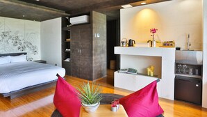 Une chambre moderne avec un grand lit, un petit bureau et un coin cuisine.