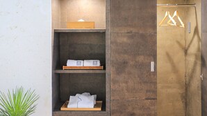 Une salle de bain avec une étagère en bois où sont rangées des serviettes et une petite boîte en bois.