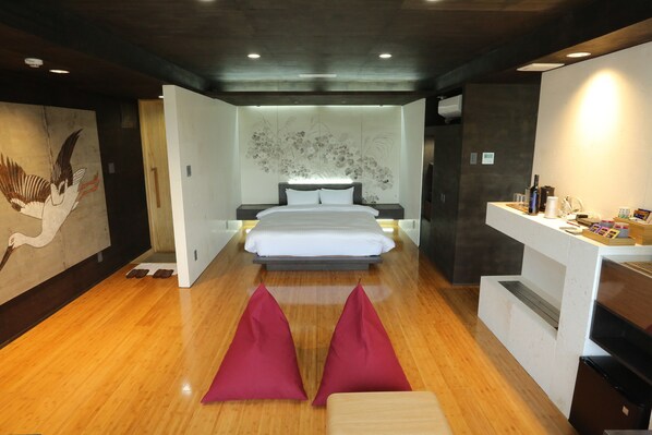 A modern bedroom with a large bed, a bedside table, and a wall-mounted artwork. - Kounosu (Nakijin)
