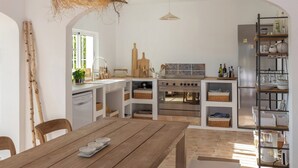 A compact kitchen with a central island, built-in appliances, and a rustic ceiling light. - Casa La Paz, trendy home of peace. (Faro)