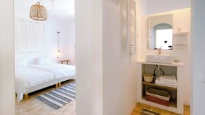 A bedroom with a bed, bedside table, lamp, and a hanging light fixture. - Casa La Paz, trendy home of peace. (Faro)