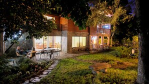 Una casa moderna con patio, sendero de piedra y terraza de madera.