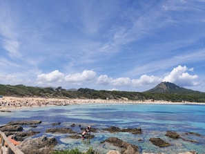 A beach with clear blue water, rocky areas, and a mountain in the background. - YourHouse Son Jaumell, spacious finca near Cala Ratjada and Capdepera golf (Capdepera)