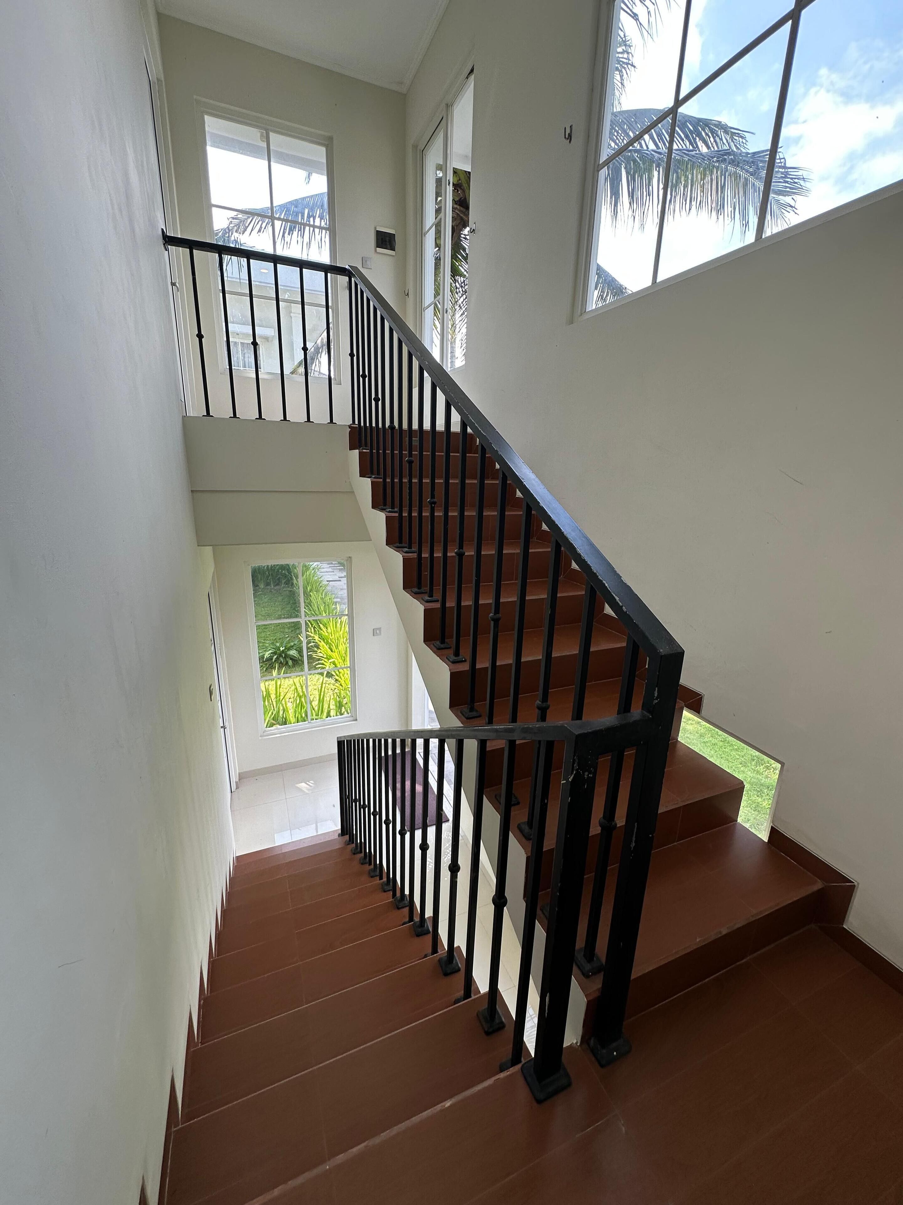 A staircase with a black railing leading to an upper floor.